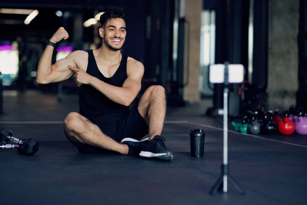 Créateur fitness en salle de sport, filmant un contenu avec smartphone sur trépied — communauté créateurs, preuve par les chiffres.